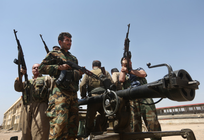 Kurdish fighters take positions on the front line with militants from the al-Qaida-inspired Islamic State in Iraq and the Levant in Tuz Khormato, 100 kilometers south of Kirkuk, northern Iraq, Wednesday.   AP-Yonhap