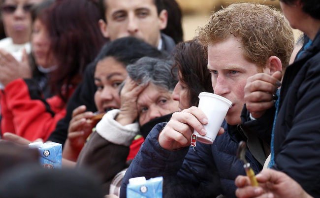 Britain’s Prince Harry visits families living in temporary housing in the El Vergel slum after they lost their homes to an April forest fire in Valparaiso, Chile, Saturday.   AP-Yonhap
