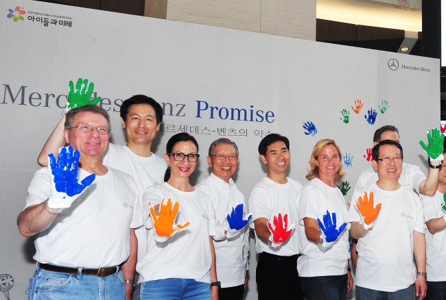Mercedes-Benz Korea CEO Britta Seeger (second from right) and other executives of Daimler Group’s local operations and dealers pose at the launch of the carmaker’s social responsibility program “Promise” at the IFC Mall in Yeouido, Seoul, Sunday.   Mercedes-Benz Korea