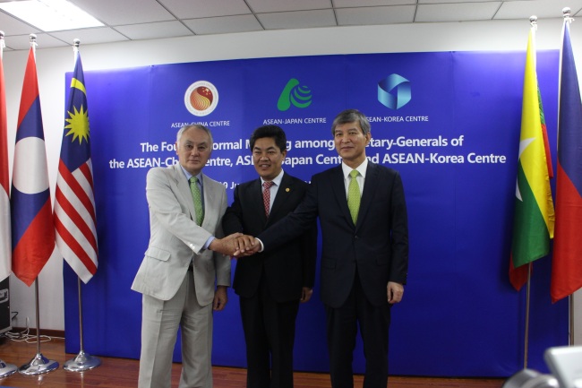 ASEAN-Korea Centre Secretary-General Chung Hae-moon (right), ASEAN-Japan Centre Secretary-General Yoshikuni Ohnishi (left) and ASEAN-China Centre Secretary-General Ma Mingqiang clasp hands during the fourth three-way meeting on enhancing cooperation between ASEAN and the “plus three” countries in Beijing, China, June 19. ASEAN-Korea Centre