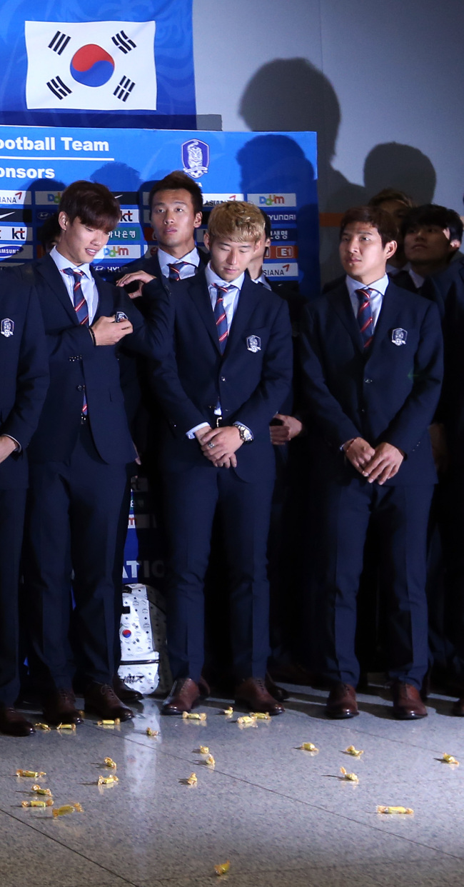 2014 브라질 월드컵 조별 리그에서 탈락한 한국 축구 대표팀이 30일 오전 인천국제공항을 통해 귀국했다. 이 과정에서 단체사진을 찍으려는 선수들에게 일부 팬들이 엿을 던지며 심한 야유를 보냈다.