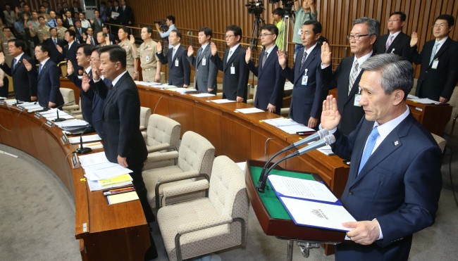 Government officials including Defense Minister Kim Kwan-jin (right) take oaths to testify before the National Assembly’s Sewol investigations committee on Monday at the National Assembly.   Lee Gil-dong/The Korea Herald