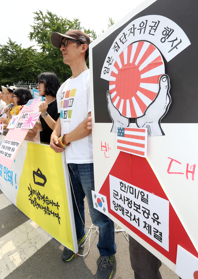Members of Solidarity for Peace and Reunification of Korea, a civic group, stage a rally in protest against Japan’s new self-defense bill in front of the headquarters of the Defense Ministry in central Seoul on Monday.   Yonhap