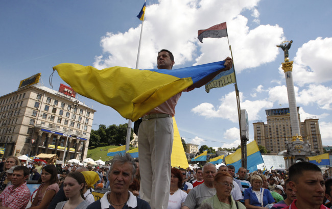 Demonstrators with Ukrainian national flags stage a rally in Kiev’s Independence Square.   ITAR-TASS-Yonhap