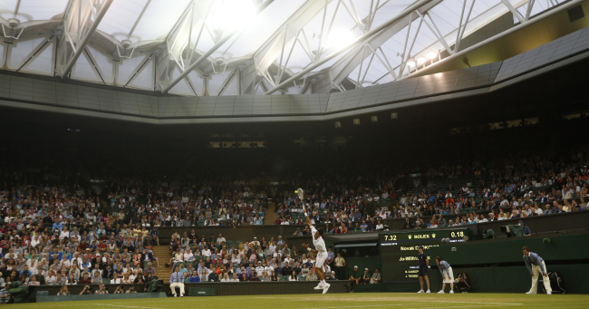 Novak Djokovic serves to Jo-Wilfried Tsonga at the Wimbledon on Monday.   AP-Yonhap