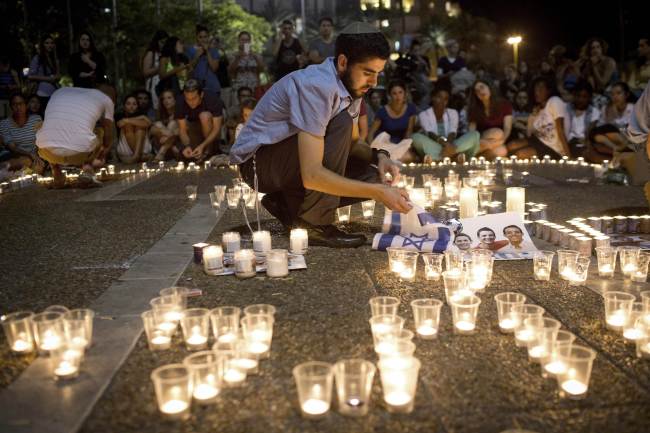 Israelis mourn and light candles in Rabin Square in Tel Aviv on Monday after the government announced that the bodies of three missing Israeli teenagers were found. Israel confirmed finding the bodies of three teenagers who disappeared in the southern West Bank on June 12, blaming the Islamist Hamas movement for their kidnapping and murder.   AFP-Yonhap