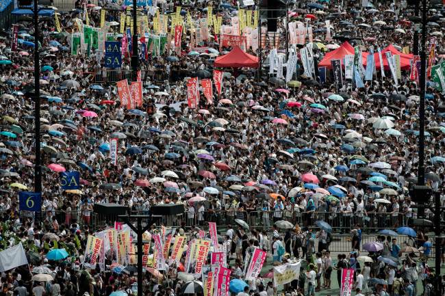 Demonstrators gather before a pro-democracy rally seeking greater democracy in Hong Kong on Tuesday as frustration grows over the influence of Beijing on the city.   AFP-Yonhap