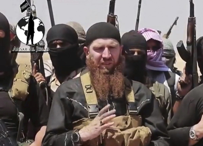 This image shows Omar al-Shishani standing next to the group’s spokesman among a group of fighters as they declare the elimination of the border between Iraq and Syria.   AP-Yonhap