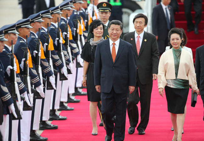 Chinese President Xi Jinping and first lady Peng Liyuan inspect honor guards as they arrive at Seoul Airport in Seongnam, Gyeonggi Province, Thursday.   Yonhap