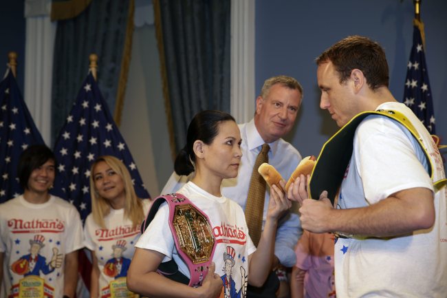 Nathan’s hot dog-eating champion Joey Chestnut (right) does a stare down with Sonya “The Black Widow” Thomas (left) at the weigh-in for Nathan’s July 4 hot dog-eating contest at City Hall in New York on Thursday.   EPA-Yonhap