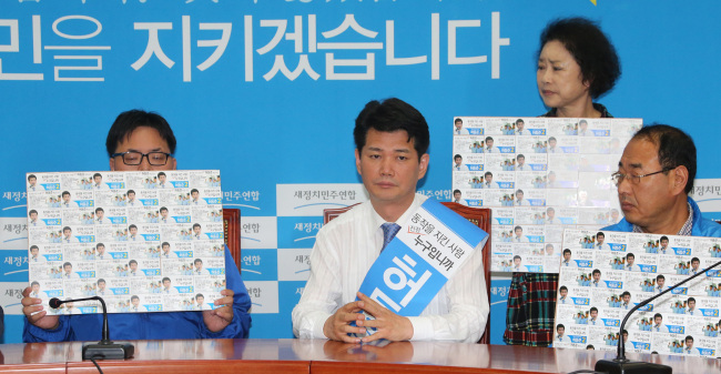 Heo Dong-jun (center) and his supporters stage a sit-in protest over Ki Dong-min’s nomination in the National Assembly on Friday.   Yonhap
