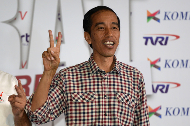 Joko Widodo, governor of Jakarta and presidential candidate, shows a victory sign as he arrives for a debate against opponent Prabowo Subianto in Jakarta on Saturday.   Bloomberg