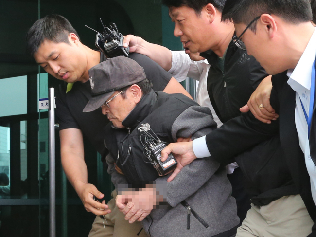 Police escort Yoo Byung-il, the elder brother of wanted man Yoo Byung-eun, to the Incheon District Prosecutors’ Office on June 11. (Yonhap)