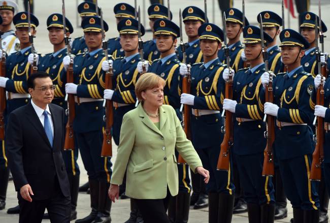 German Chancellor Angela Merkel reviews an honor guard with Chinese Premier Li Keqiang (left) during a welcome ceremony outside the Great Hall of the People in Beijing on Monday.   AFP-Yonhap