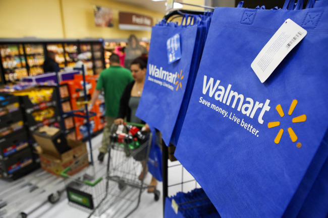 Customers push carts past reusable shopping bags during the grand opening of a Wal-Mart store in Los Angeles.   Bloomberg