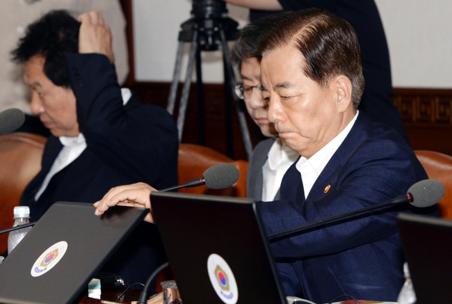한민구(오른쪽) 신임 국방장관이 8일 오전 정부 세종로청사에서 열린 국무회의에 첫 참석해 노트북을 열고 있다. 박현구 기자phko@heraldcorp.com 2014.07.08