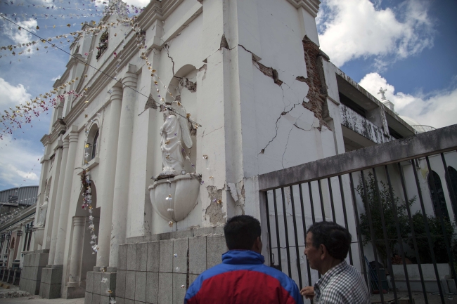 Two men review fractures on the exterior walls of a Catholic church, after an earthquake in San Pedro, Guatemala, Monday.   AP-Yonhap