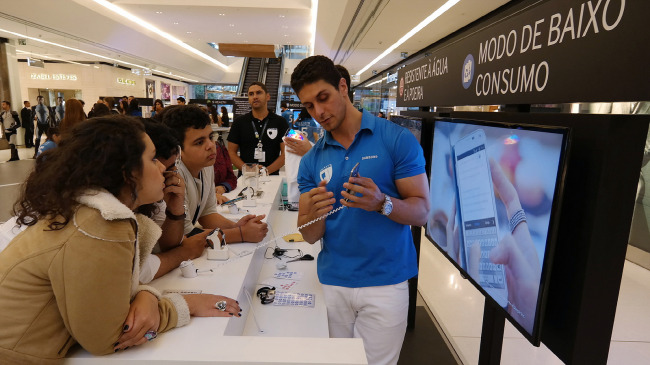 An employee demonstrates features of Samsung Electronics’ products to visitors at the Galaxy 11 World Tour in San Paulo on June 9.   Samsung Electronics