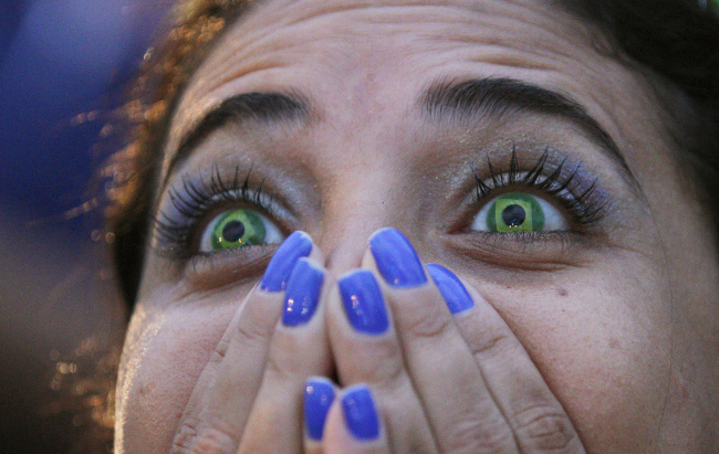 <YONHAP PHOTO-0539> A Brazil soccer fan wearing contact lenses that mimic the Brazilian flag reacts as she watches her team play Germany in a World Cup semifinal game via live telecast inside the FIFA Fan Fest area on Copacabana beach in Rio de Janeiro, Brazil, Tuesday, July 8, 2014. (AP Photo/Leo Correa)/2014-07-09 07:44:10/ <저작권자 ⓒ 1980-2014 ㈜연합뉴스. 무단 전재 재배포 금지.>
A fan wearing Brazilian-flag contact lenses watches her team play Germany on Tuesday.
AP-Yonhap