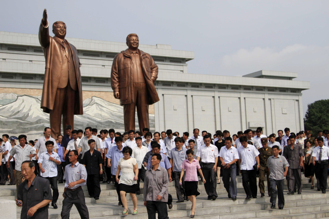North Koreans visit the statues of late leaders Kim Il-sung (left) and Kim Jong-il on Mansu Hill in Pyongyang, Tuesday, marking the 20th anniversary of the former’s death.   AP-Yonhap