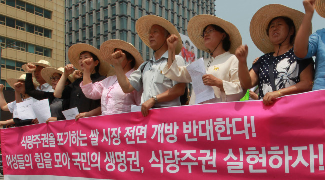 Farmers take to the streets in Gwanghwamun, Seoul, on June 17, to protest against Korea’s rice market opening to foreign producers.   Yonhap