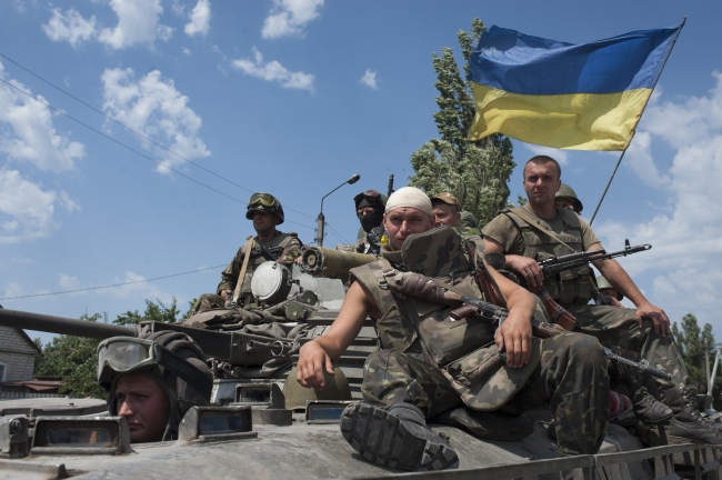 Ukrainian government soldiers ride atop an armored personal carrier with a Ukrainian national flag outside the city of Siversk, Donetsk region, eastern Ukraine, Saturday.   AP-Yonhap
