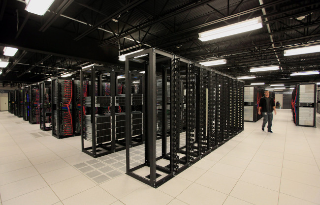An employee walks past rows of racks being built and prepared for use in IBM’s Softlayer data center in Dallas, Texas, in January.   Bloomberg