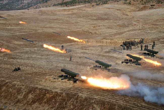 A North Korean artillery unit is seen engaged in a live-fire drill in a photograph released by Pyongyang’s Rodong Sinmun in March. (Yonhap)