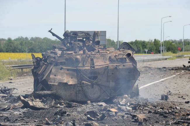 A destroyed armored vehicle is seen on the road of the airport in the south of Lugansk, Ukraine, Monday.   AFP-Yonhap