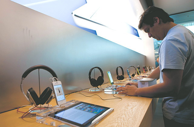 A customer tries an Apple Inc. iPad during the opening of the first Apple store in Latin America, located at the
Village mall in Rio de Janeiro. Bloomberg
