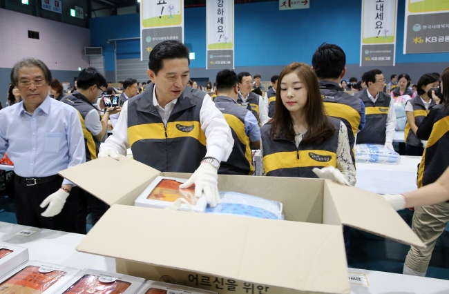 임영록(왼쪽) KB금융지주 회장과 피겨여왕 김연아 선수가 어르신들의 시원한 여름 나기를 돕기 위한 여름 생활용품을 포장하고 있다.  [사진제공=KB금융]