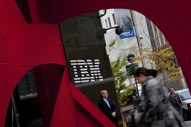 Pedestrians walk past IBM’s offices in New York.   Bloomberg