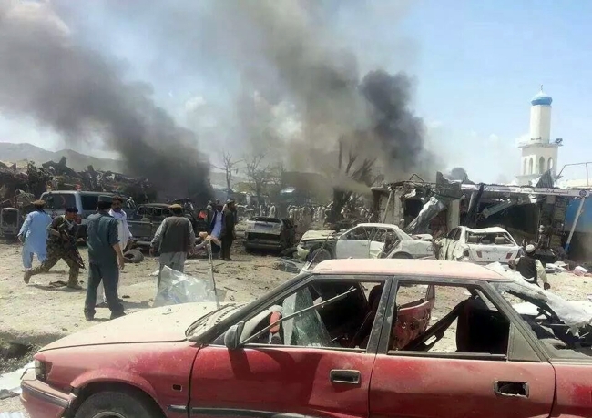 Afghan security forces and civilians walk at the site of a suicide attack in the Urgun area of Paktika province, Afghanistan, Tuesday.   AP-Yonhap