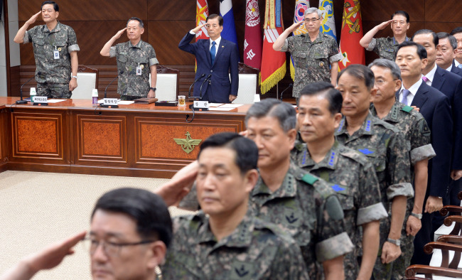 Defense Minister Han Min-koo (third from left) and top uniformed officers pledge allegiance to the national flag as the meeting of top military commanders begins at the ministry in Seoul on Wednesday.   Ahn Hoon/The Korea Herald