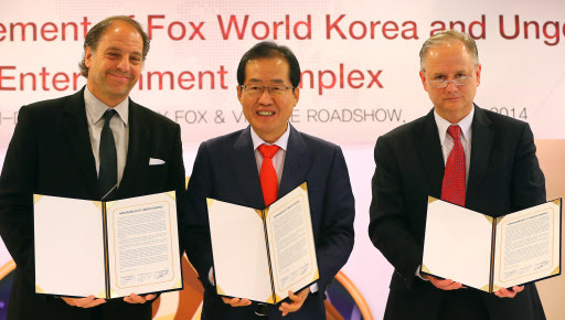 South Gyeongsang Province, 20th Century Fox and Village Roadshow signed a three-party MOU on Wednesday to build a global theme park in the Busan-Jinhae FEZ by 2018. (From left) Fox Consumer Products president Jeffrey Godsick, South Gyeongsang Gov. Hong Joon-pyo and Village Roadshow CEO Tim Fisher. Yonhap
홍준표 경남 도지사와 20세기 폭스 컨슈머 프로덕트(Twentieth Century Fox Consumer Products)의 사장 제프리 갓식(Jeffrey Godsick), 빌리지 로드쇼 테마파크(Village Roadshow Theme Parks)의 CEO 팀 피셔(Tim Fisher)는 현지시간 2014년 7월 16일 11시, 한국언론진흥재단의 외신 기자 클럽에서 한국 최초의 국제 테마파크 및 리조트인 20세기 폭스 월드(Twentieth Century Fox World)를 조성하기 위한 MOU(양해각서)를 체결했다. 해당 대규모 테마파크는, 현재 많은 기대 속에 활발한 개발이 추진되고 있는 웅동 엔터테인먼트 단지에 위치하게 된다.
South Gyeongsang Province, 20th Century Fox and Village Roadshow signed a three-party MOU on Wednesday to build a global theme park in the Busan-Jinhae FEZ by 2018. (From left) Fox Consumer Products president Jeffrey Godsick, South Gyeongsang Gov. Hong Joon-pyo and Village Roadshow CEO Tim Fisher. Yonhap