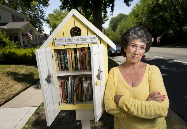 Georgiana White stands with the Little Library in front of her home in Sacramento, California. (Sacramento Bee/MCT)