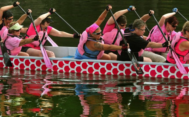 Members of the Dragon Dream Team, Tara Reynolds (from left), Dianna Harris,
Susan Coleville-Hall, Stephanie Desarro, Sue Cingel, Betsy Lambright and Linda Latham, prepare to drive their paddles into the water during a practice session on Rex Lake, in Akron, Ohio, on July 2. (Akron Beacon Journal/MCT)