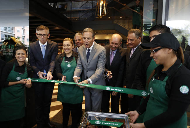 Starbucks CEO Howard Schultz (center) takes part in the opening ceremony of the first Starbucks in Colombia on Wednesday.   AP-Yonhap