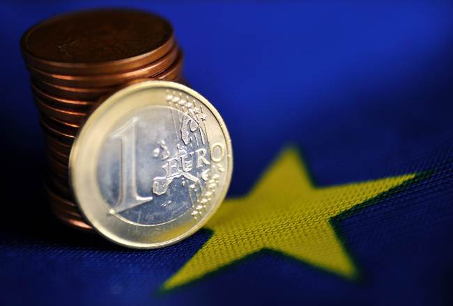 A 1 euro coin and a pile of eurocents is displayed on a European Union flag.   AFP-Yonhap