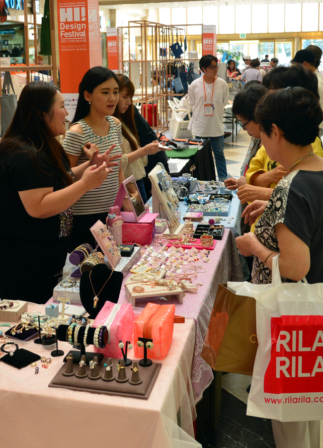 Visitors purchase items at the Hi Design Festival’s design market held in Seoul on Friday.   Yoon Byung-chan/The Korea Herald