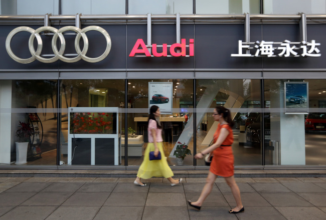 Pedestrians walk past an Audi AG dealership in Shanghai.   Bloomberg