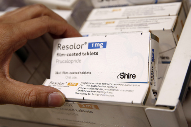 A pharmacist removes a box of Shire Resolor 1 mg prolonged film-coated tablets from a storage drawer at a pharmacy in London.   Bloomberg