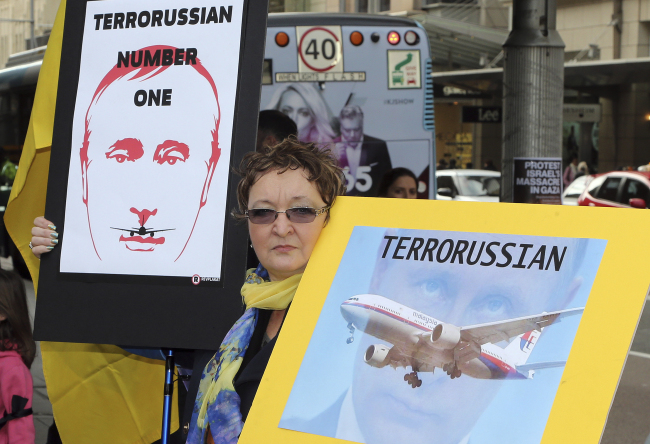A woman holds an anti-Putin placards during a rally to protest the downing of Malaysia Airlines Flight MH17 in Sydney, Australia, Saturday.   AP-Yonhap