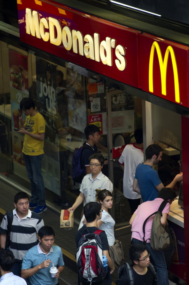 Pedestrians walk past a McDonald’s in Hong Kong.   Bloomberg