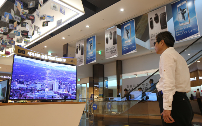 A man watches a TV at Samsung Electronics’ D’light exhibition hall installed at the firm’s headquarters in southern Seoul.   Samsung Electronics