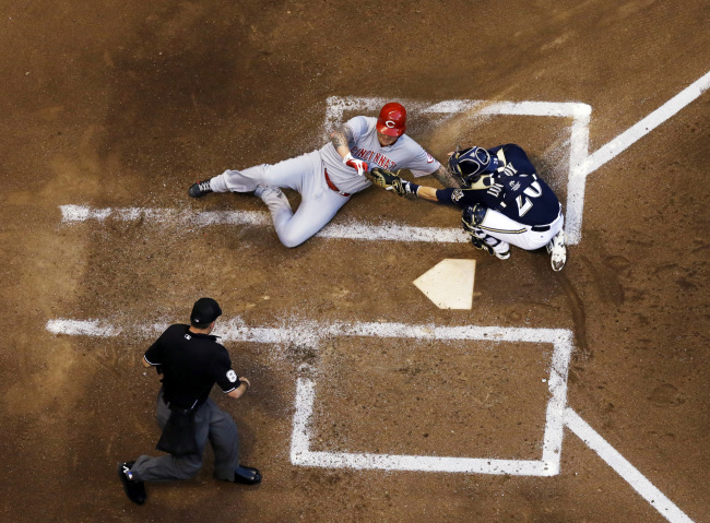 Milwaukee Brewers catcher Jonathan Lucroy tags out Cincinnati Reds pitcher Mat Latos at home plate in the third inning on Monday.   AP-Yonhap