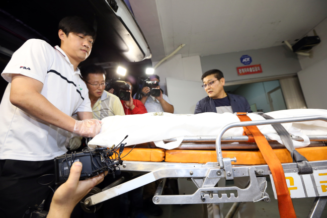 Investigators move the body confirmed by police to be that of the ill-fated Sewol operator Yoo Byung-eun into an ambulance at a hospital in Suncheon, South Jeolla Province, Tuesday. The body was handed over to the Seoul unit of the National Forensic Service.   Yonhap