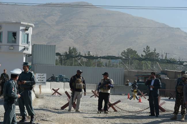 Foreign security guards and Afghan policemen keep watch at the site of a suicide attack in a compound in Kabul on Tuesday.   AFP-Yonhap