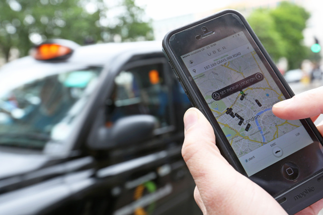A user scans for an available vehicle using the Uber application in London.   Bloomberg