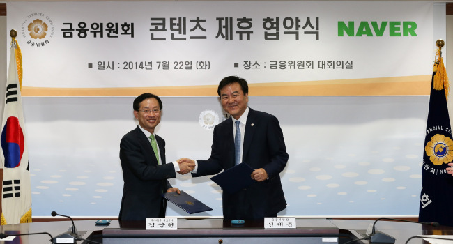 Financial Services Commission chairman Shin Je-yoon (right) and Naver CEO Kim Sang-hun wrap up a memorandum of understanding outlining a partnership for publishing key financial information on the portal, at the FSC building in central Seoul on Tuesday.   FSC